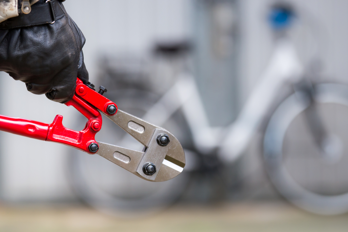 un homme avec une pince coupante va voler un vélo