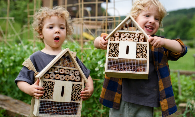 deux enfants avec des hôtels à insectes