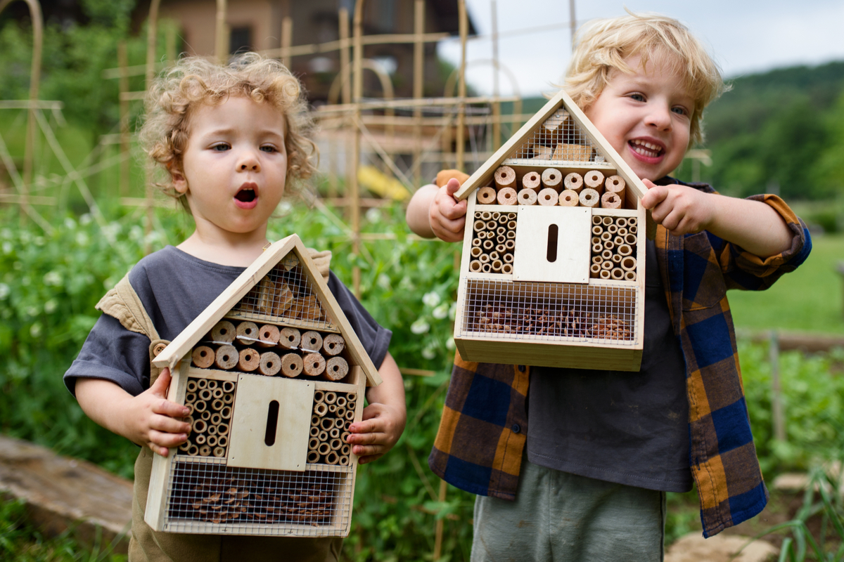 deux enfants avec des hôtels à insectes