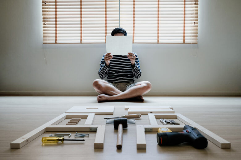 Un homme lit une notice d'un meuble IKEA