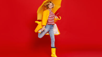 Une femme avec un parapluie jaune sur fond rouge