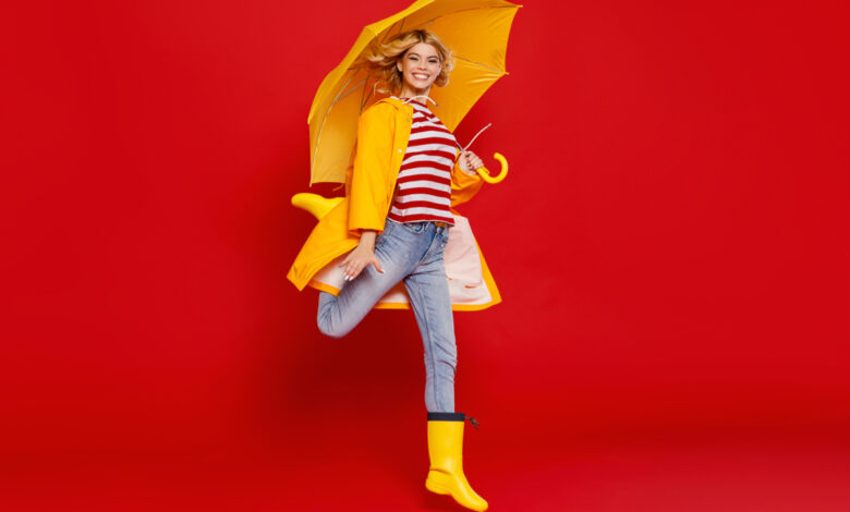 Une femme avec un parapluie jaune sur fond rouge