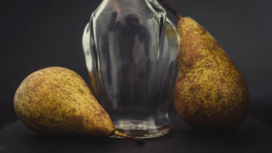 Une bouteille en verre et trois poires