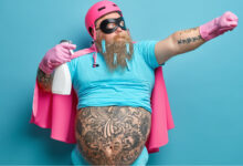 une homme barbu avec des tatouages habillé en rose
