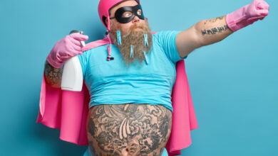 une homme barbu avec des tatouages habillé en rose