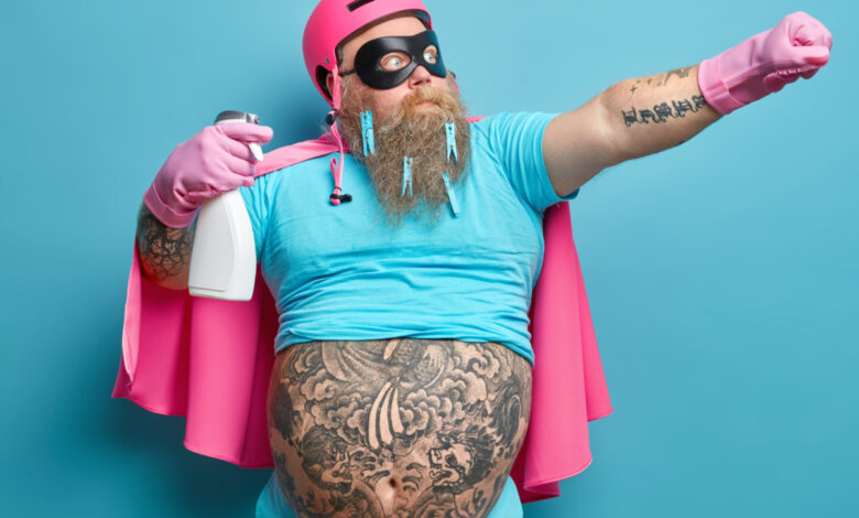 une homme barbu avec des tatouages habillé en rose