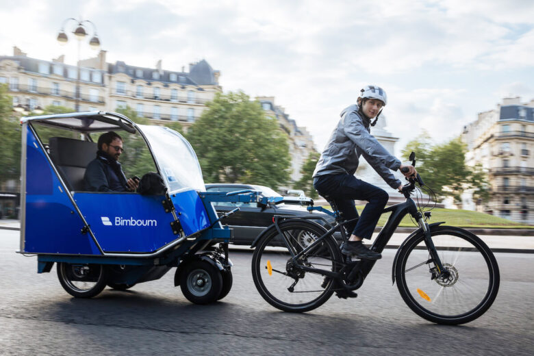 un homme pédale sur un vélo cargo taxi