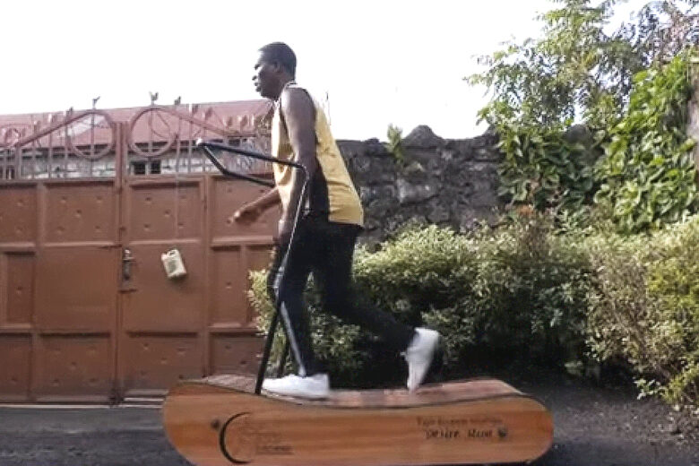 un homme courre sur un tapis de course en bois