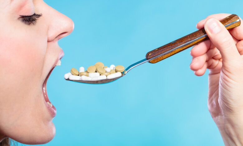 une femme avale des médicaments dans une cuillère