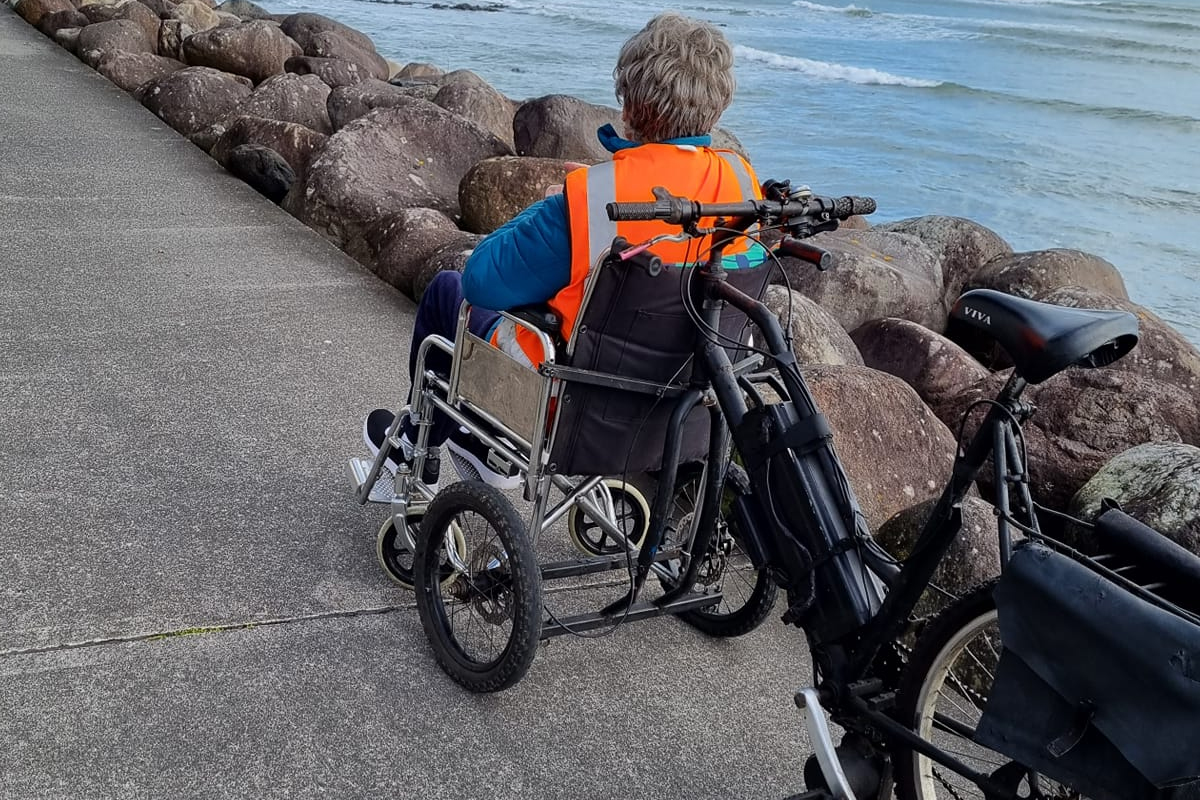 Un vélo jumelé avec un fauteuil roulant