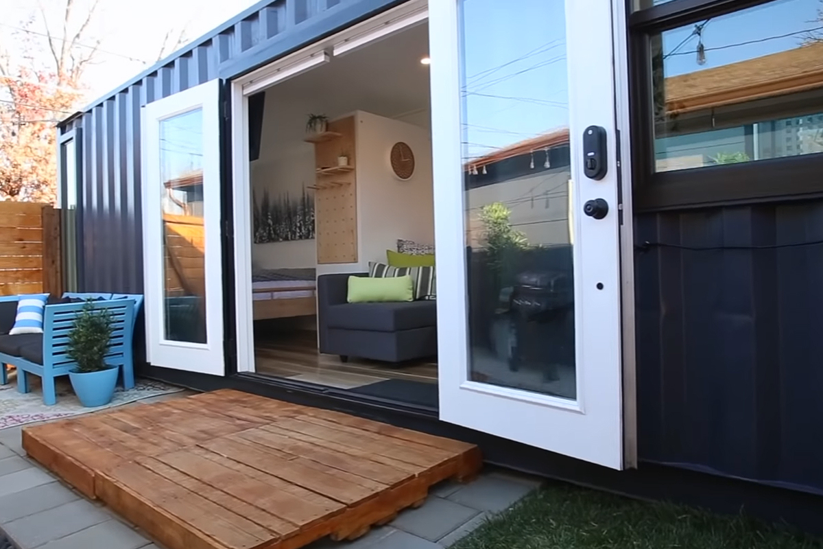 Une magnifique maison container placée dans un arrière-cour.