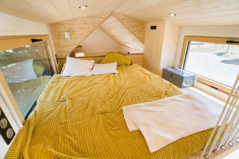 Une chambre avec un lit double et un plafond bas.