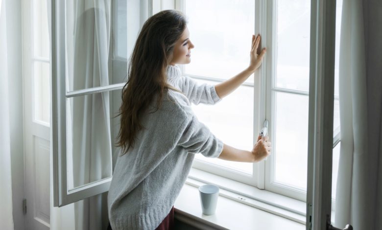 Une femme devant une fenêtre.