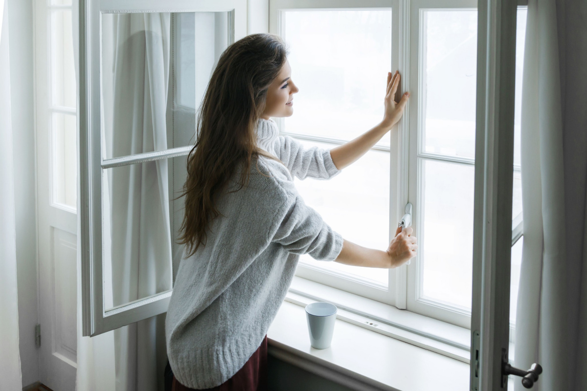 Une femme devant une fenêtre.