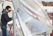 Peng Zhou utilise une grande lentille pour concentrer la lumière du soleil sur le catalyseur