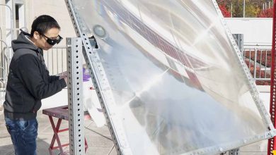 Peng Zhou utilise une grande lentille pour concentrer la lumière du soleil sur le catalyseur