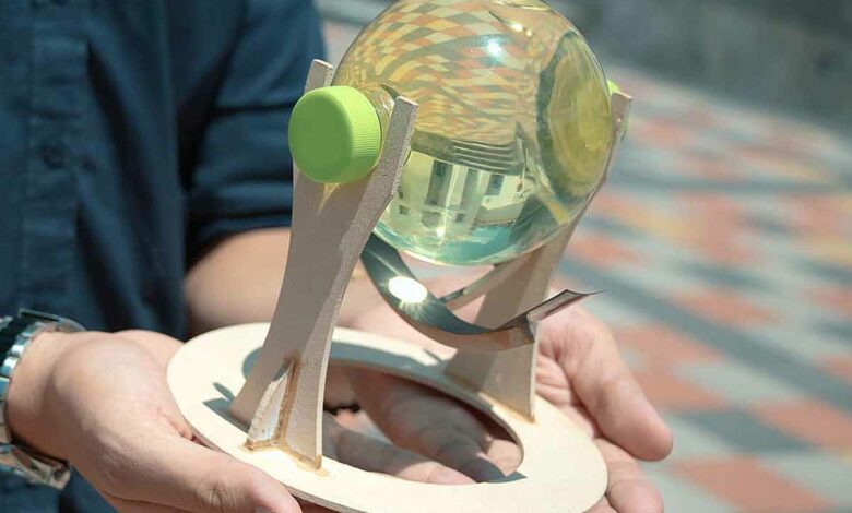 Une sphère qui capte les rayons du soleil et les concentre sur un point fixe, maximisant ainsi l'intensité de la lumière à tout moment de la journée. Contrairement aux autres panneaux solaires, le panneau solaire flexible situé sous la sphère permet d'obtenir le rendement maximal du panneau, car il garantit que les rayons atteignent toujours un angle de 90°. Fabriqué à partir de matériaux recyclés : une bouteille en forme de sphère remplie d'eau et des morceaux de bois récupérés.