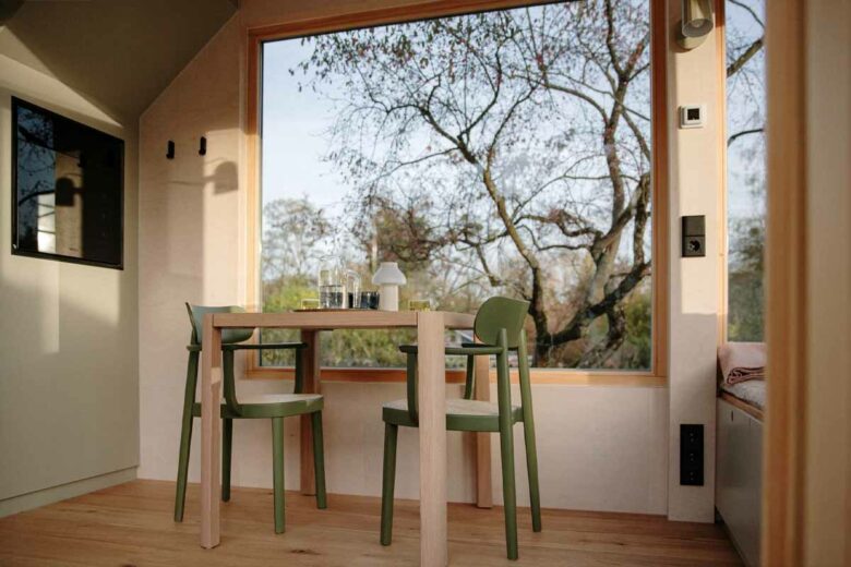 L'intérieur de la maison est imprégné d'un style moderne et confortable, offrant toutes les commodités essentielles. De plus, de grandes fenêtres panoramiques permettent une vue étendue et le mobilier en bois ajoute une touche chaleureuse à l'ensemble.