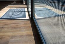 Des stries inclinées à l'aspect miroir argenté sont appliquées sur un vitrage feuilleté pour servir de protections solaires. Cette solution peut être utilisée dans des structures à double vitrage, offrant des performances supplémentaires en termes d'isolation acoustique ou de résistance aux intrusions.