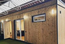 Une maison container bardée de bois.
