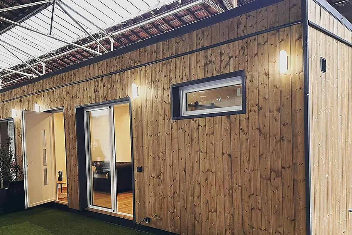 Une maison container bardée de bois.