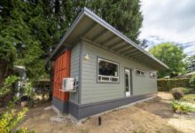 Une maison container hybride qui comprend un conteneur d'expédition à l'arrière et une partie à ossature de bois à l'avant.