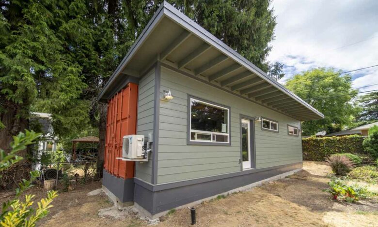 Une maison container hybride qui comprend un conteneur d'expédition à l'arrière et une partie à ossature de bois à l'avant.