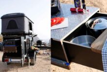 Une petite remorque caravane équipée d'une tente de toit.
