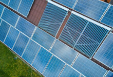 Une installation de panneaux photovoltaïques et de collecteurs de tubes à vide sur la toiture d'un bâtiment.
