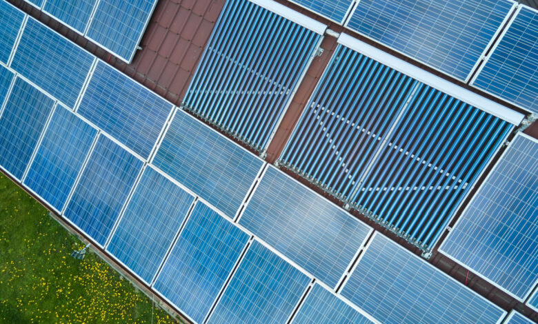 Une installation de panneaux photovoltaïques et de collecteurs de tubes à vide sur la toiture d'un bâtiment.