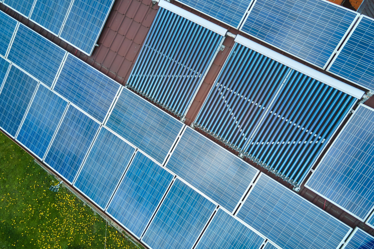 Une installation de panneaux photovoltaïques et de collecteurs de tubes à vide sur la toiture d'un bâtiment.