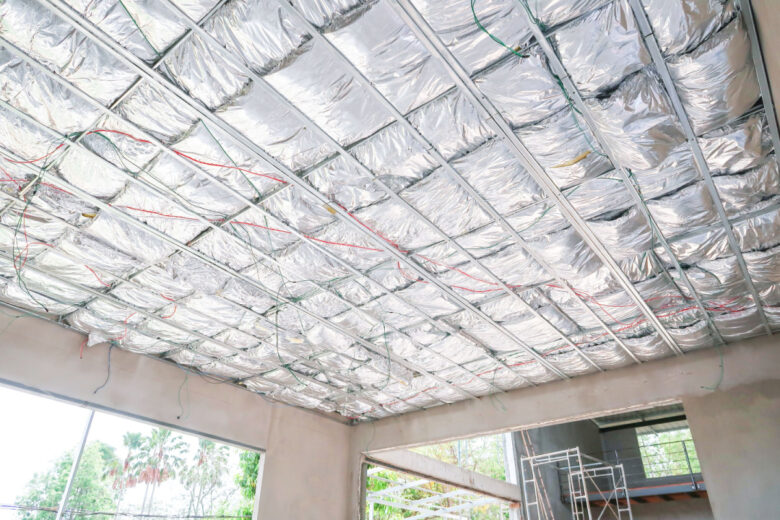 Travaux d'isolation thermique d'un plafond avec de l'isolant multicouches.