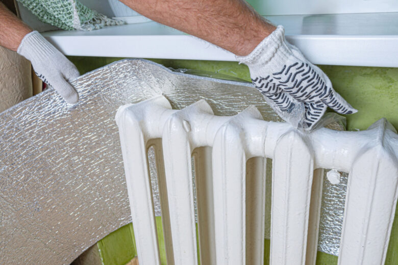 Pose d'un réflecteur de radiateur aluminisé.