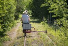 Deux personnes se baladant avec un rail bike sur une voie ferrée désaffectée.