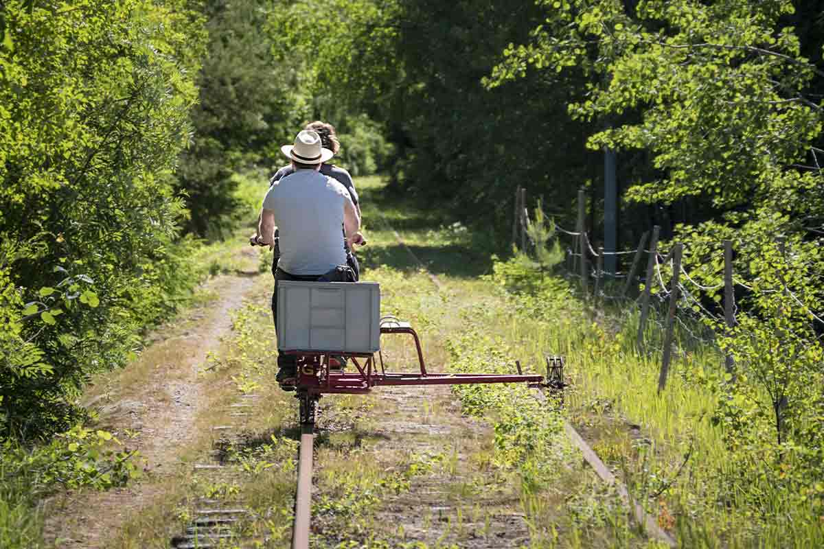 Deux personnes se baladant avec un rail bike sur une voie ferrée désaffectée.