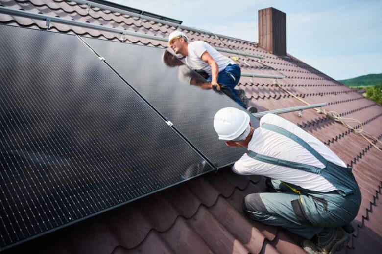 Des ouvriers qui réalisent une installation de panneaux solaires.