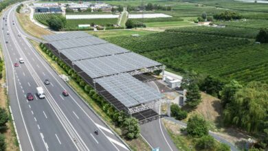 Des aires d'autoroutes recouvertes de structures rétractables avec des panneaux solaires.