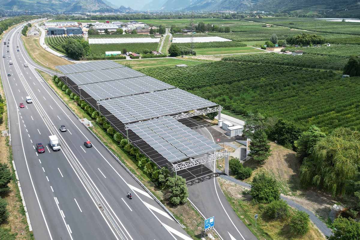 Des aires d'autoroutes recouvertes de structures rétractables avec des panneaux solaires.