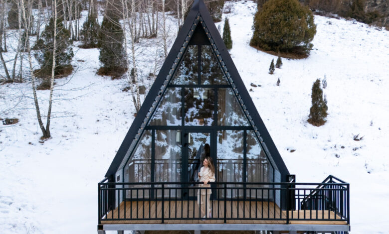 Une maison en A dans une vallée enneigée.