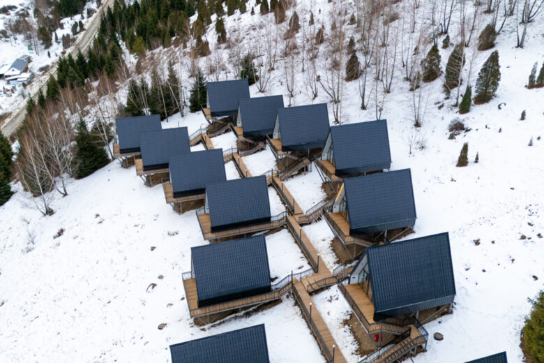 Un lotissement de maisons en A dans une vallée enneigée.