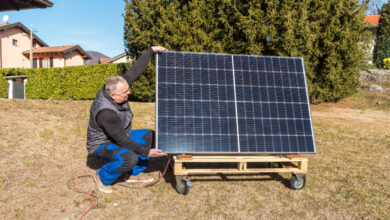 Un homme qui installe un panneau solaire sur un support à roulettes fait maison.