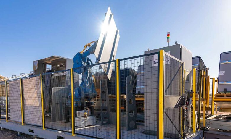 Au départ de la chaine automatisée, le robot effectue la manutention des panneaux solaires.