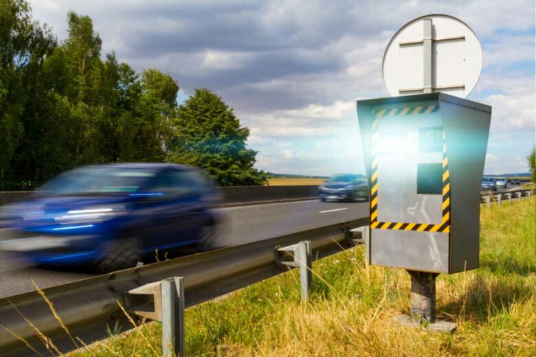 Un radar fixe sur une route qui flash des conducteurs en excès de vitesse.