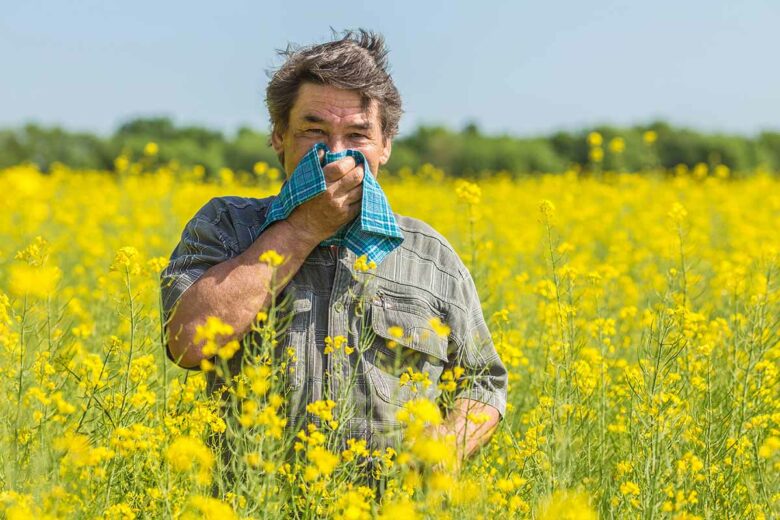 Un homme se mouchant à cause d'une allergie au pollen.