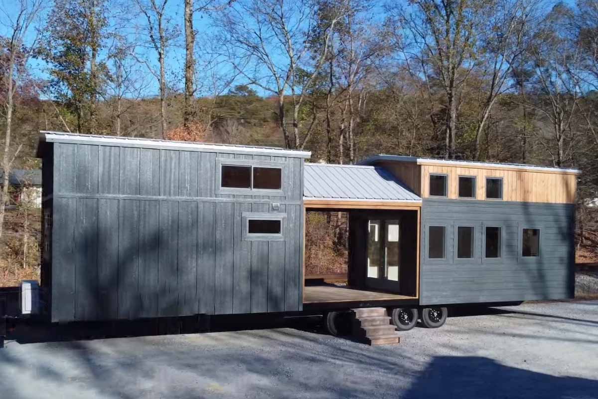 Une tiny house immense avec un porche pour séparer deux zones d'habitation distinctes.