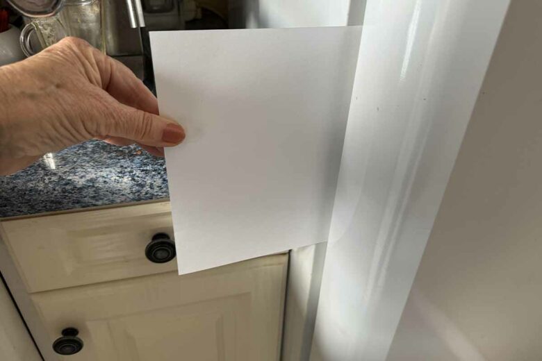 Test du joint d'étanchéité du réfrigérateur à l'aide d'une feuille de papier.