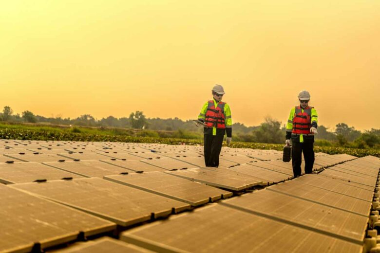 Inspection d'une ferme solaire lors d'une période de tempète de sable, ciel orangé chargé de sable provenant du Maghreb.