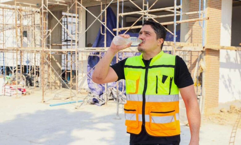 Un ouvrier qui se réhydrate sur un chantier à cause des fortes chaleurs.