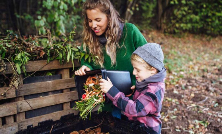 Une femme et son enfant qui font du compost dans le fond du jardin.