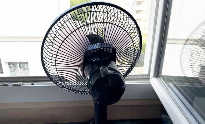 Un ventilateur placé devant la fenêtre pour évacuer la chaleur de la pièce.